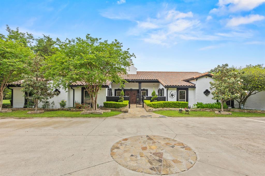 a view of a house with a big yard and large trees