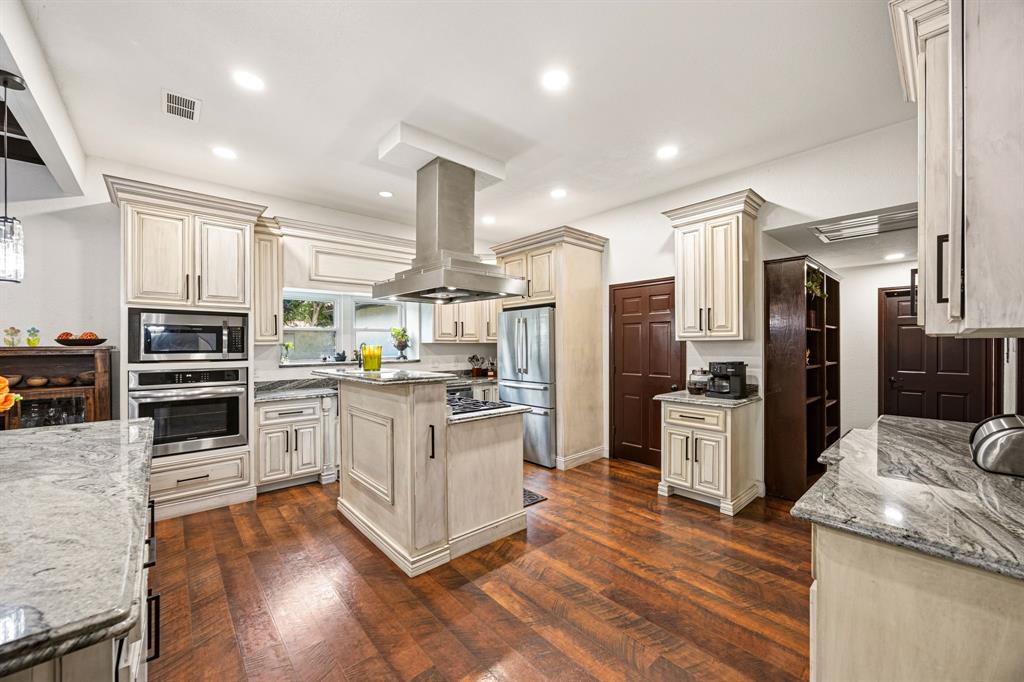 41 Graham Lane Lucas, TX 75002 - Photo 5 of 17 a kitchen with stainless steel appliances kitchen island granite countertop a refrigerator oven a sink dishwasher and white cabinets with wooden floor