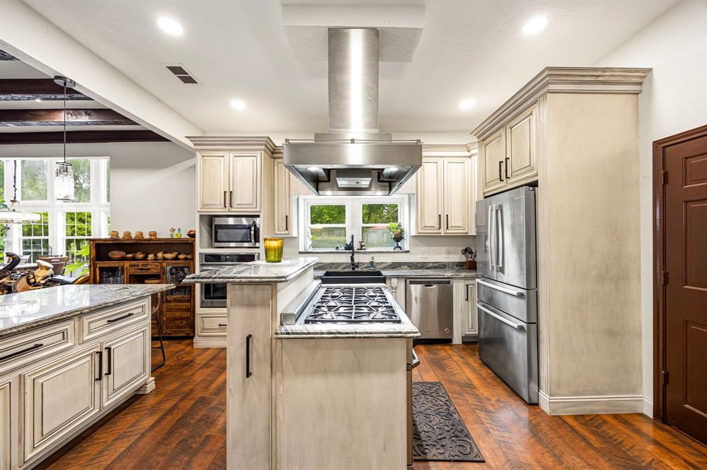 41 Graham Lane Lucas, TX 75002 - Photo 7 of 17 a kitchen with stainless steel appliances kitchen island granite countertop a refrigerator a sink dishwasher a stove and white cabinets with wooden floor