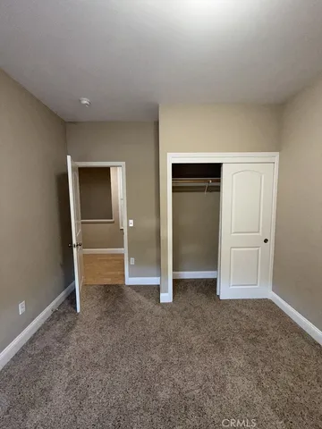 an empty room with closet and wooden door