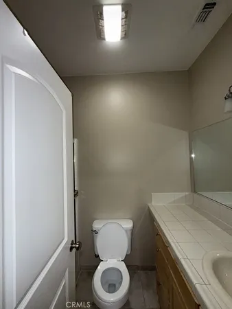 a bathroom with a granite countertop toilet and a sink