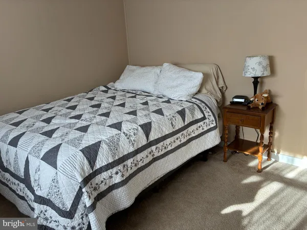 a bed sitting in a bedroom next to a lamp
