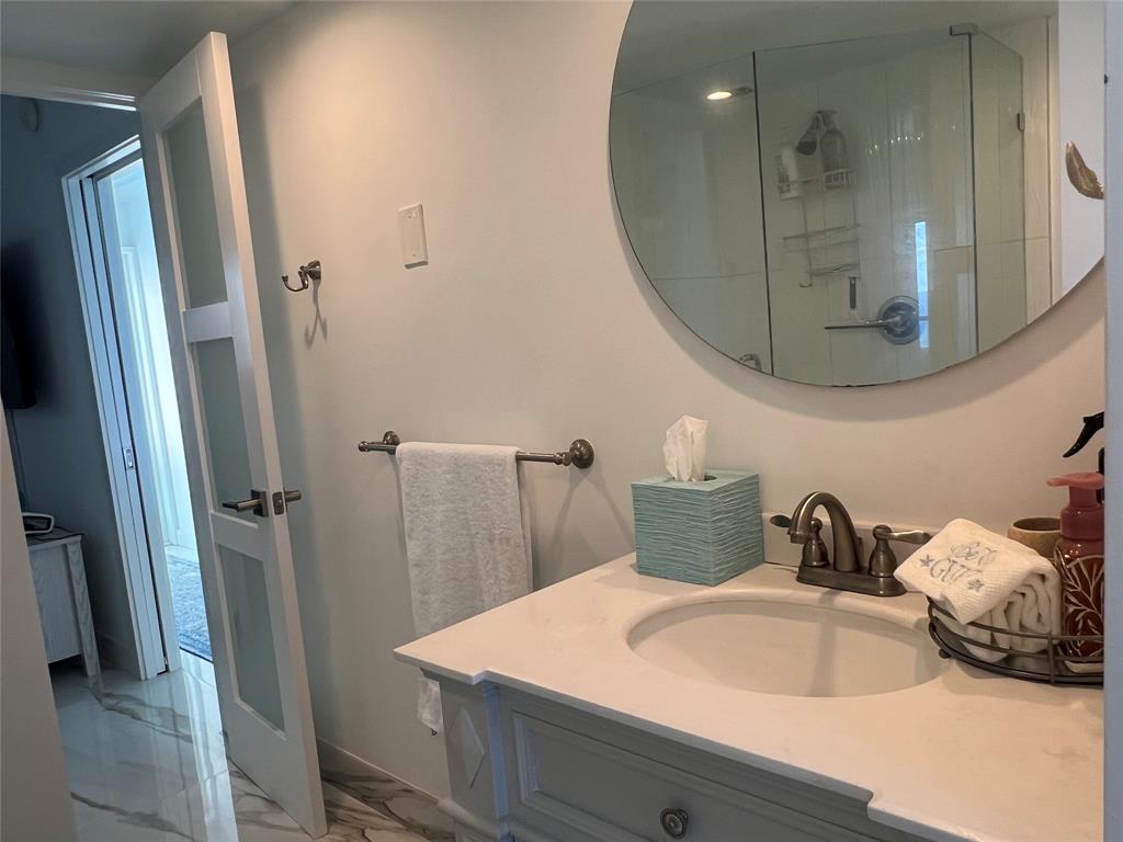 1610 North Ocean Boulevard, Unit 1202 Pompano Beach, FL 33062 - Photo 12 of 31 a bathroom with a sink a mirror and shower