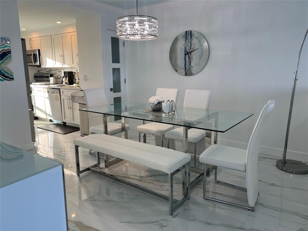 1610 North Ocean Boulevard, Unit 1202 Pompano Beach, FL 33062 - Photo 16 of 31 a living room with furniture a table chandelier and a window