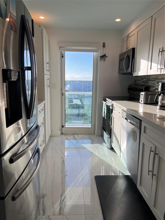1610 North Ocean Boulevard, Unit 1202 Pompano Beach, FL 33062 - Photo 18 of 31 a kitchen with stainless steel appliances a stove a refrigerator and a sink