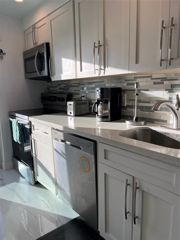 1610 North Ocean Boulevard, Unit 1202 Pompano Beach, FL 33062 - Photo 19 of 31 a kitchen with stainless steel appliances granite countertop a sink and a white cabinets