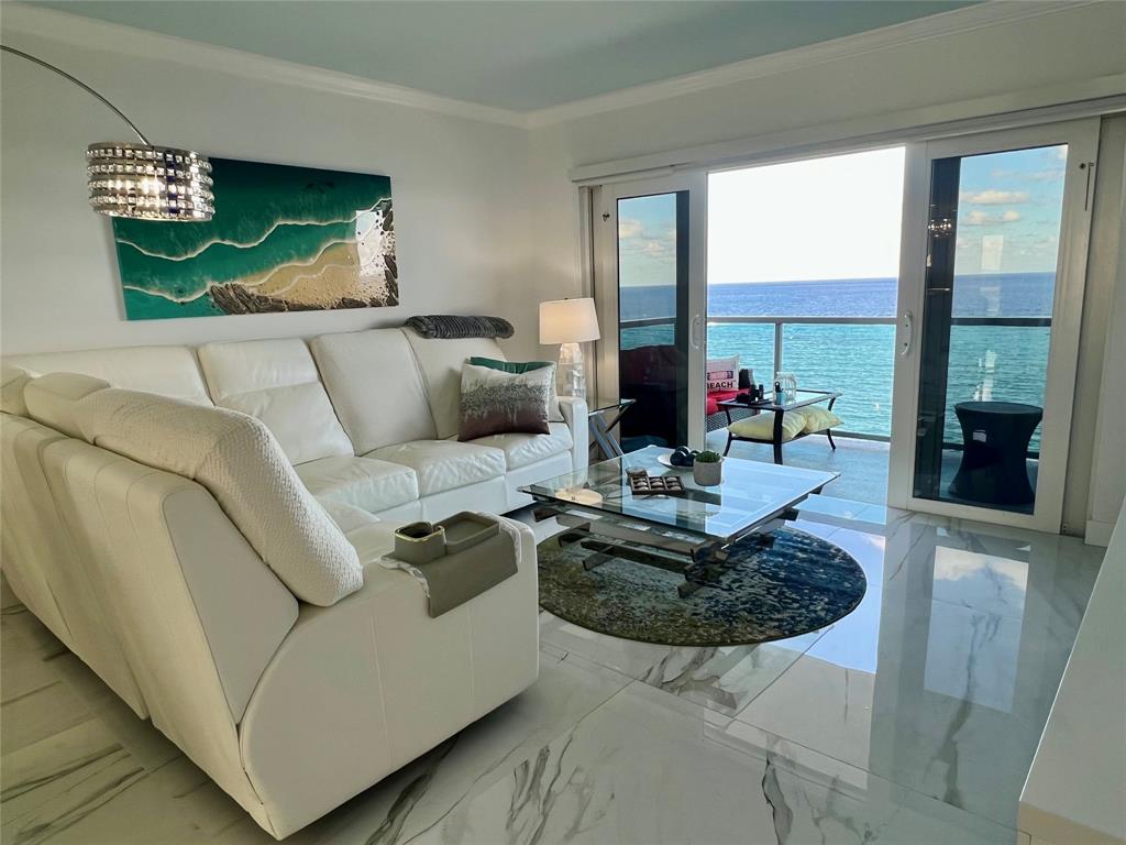 1610 North Ocean Boulevard, Unit 1202 Pompano Beach, FL 33062 - Photo 6 of 31 a living room with furniture a rug and a chandelier