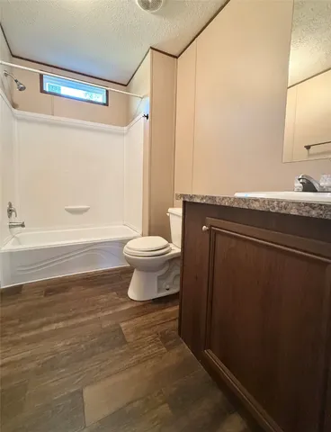 a bathroom with a sink a toilet a mirror and shower