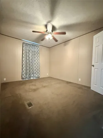 an empty room with windows and ceiling fan view