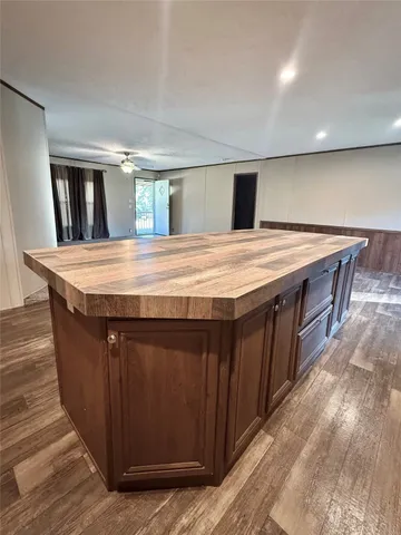 a dining hall with stainless steel appliances granite countertop a large kitchen counter tops and wooden floors