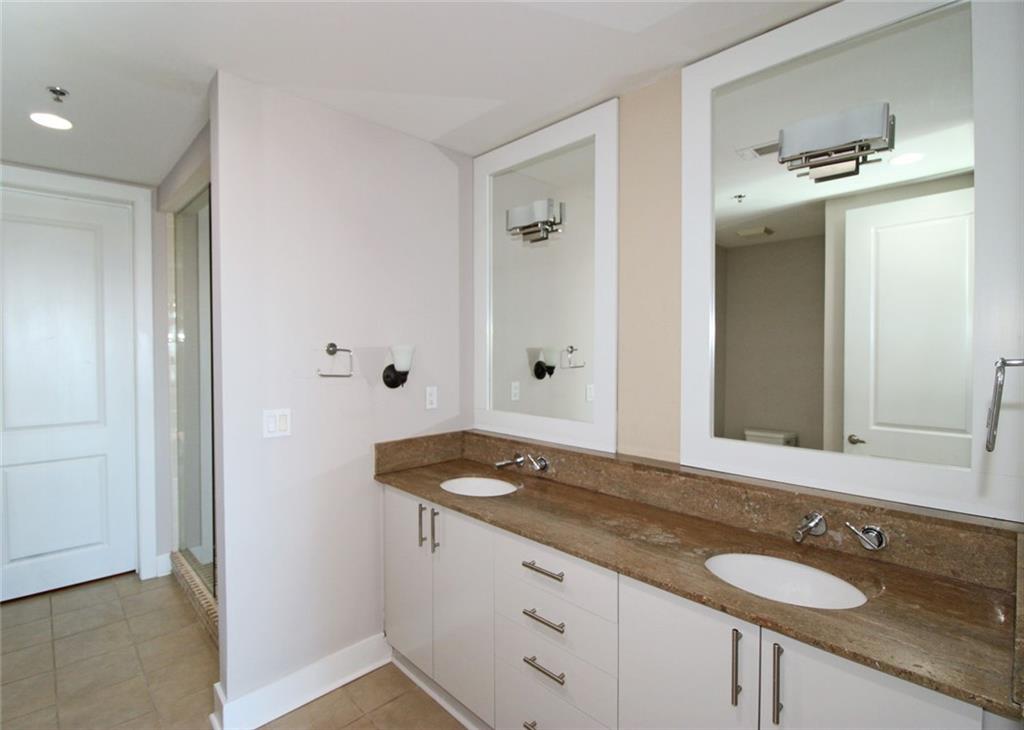 4561 Olde Perimeter Way, Unit 2102 Atlanta, GA 30346 - Photo 12 of 44 a bathroom with a granite countertop sink and a mirror