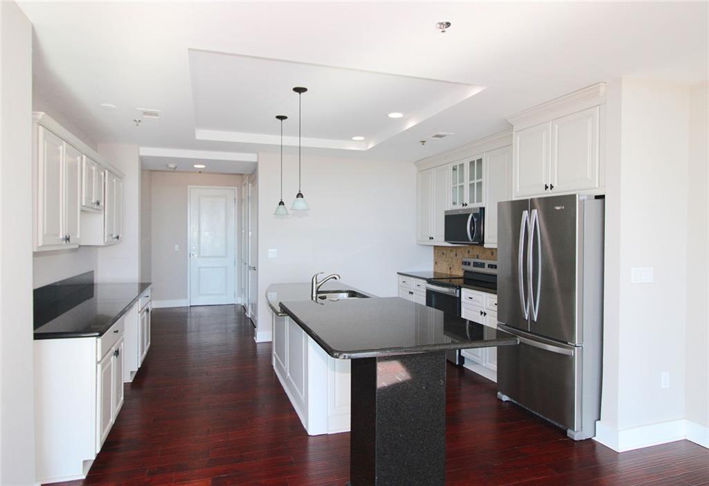 4561 Olde Perimeter Way, Unit 2102 Atlanta, GA 30346 - Photo 5 of 44 a kitchen with stainless steel appliances a refrigerator stove microwave and cabinets