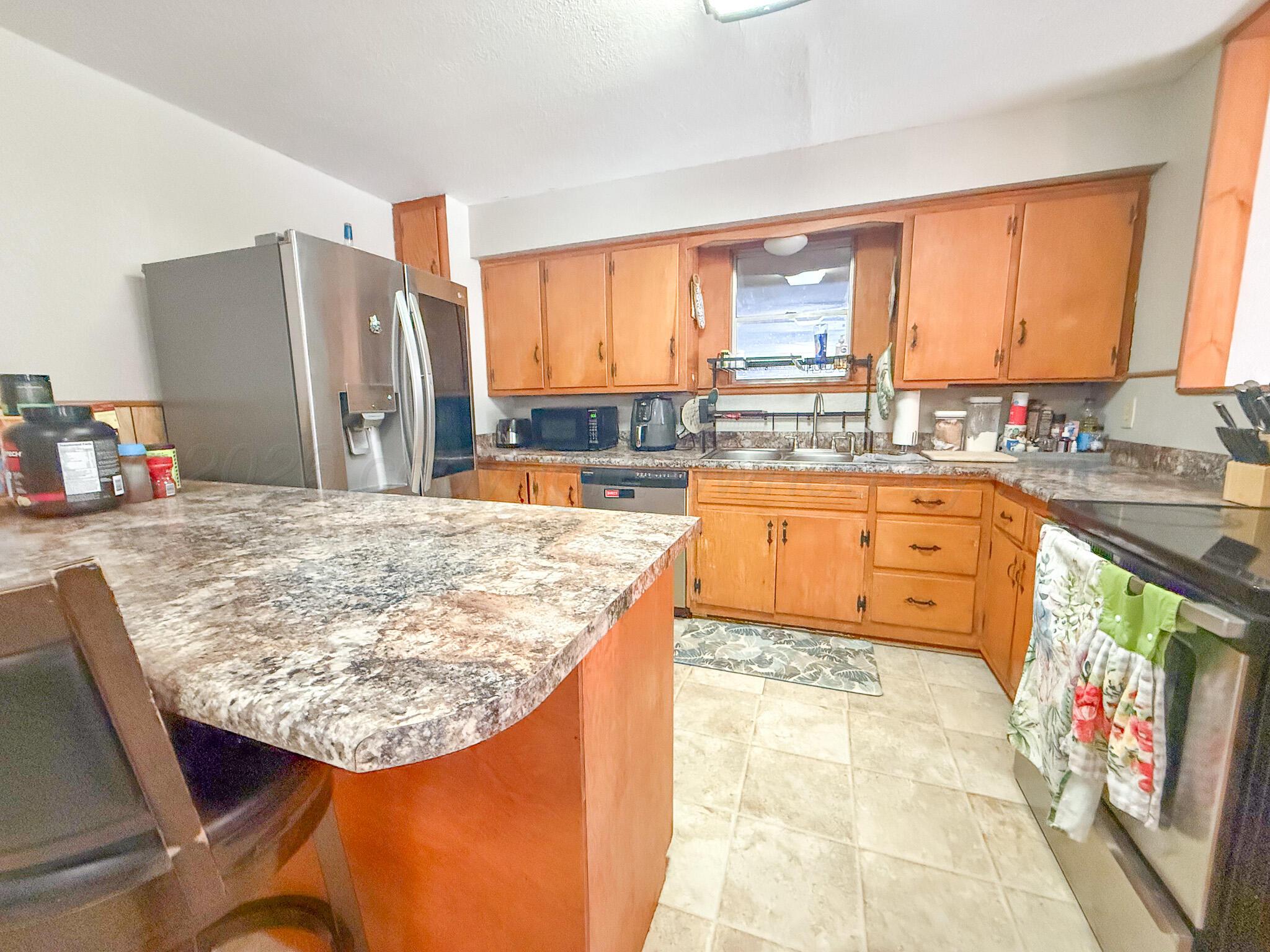702 South Canadian Street Wheeler, TX 79096 - Photo 14 of 47 a kitchen with kitchen island granite countertop a sink stove and refrigerator