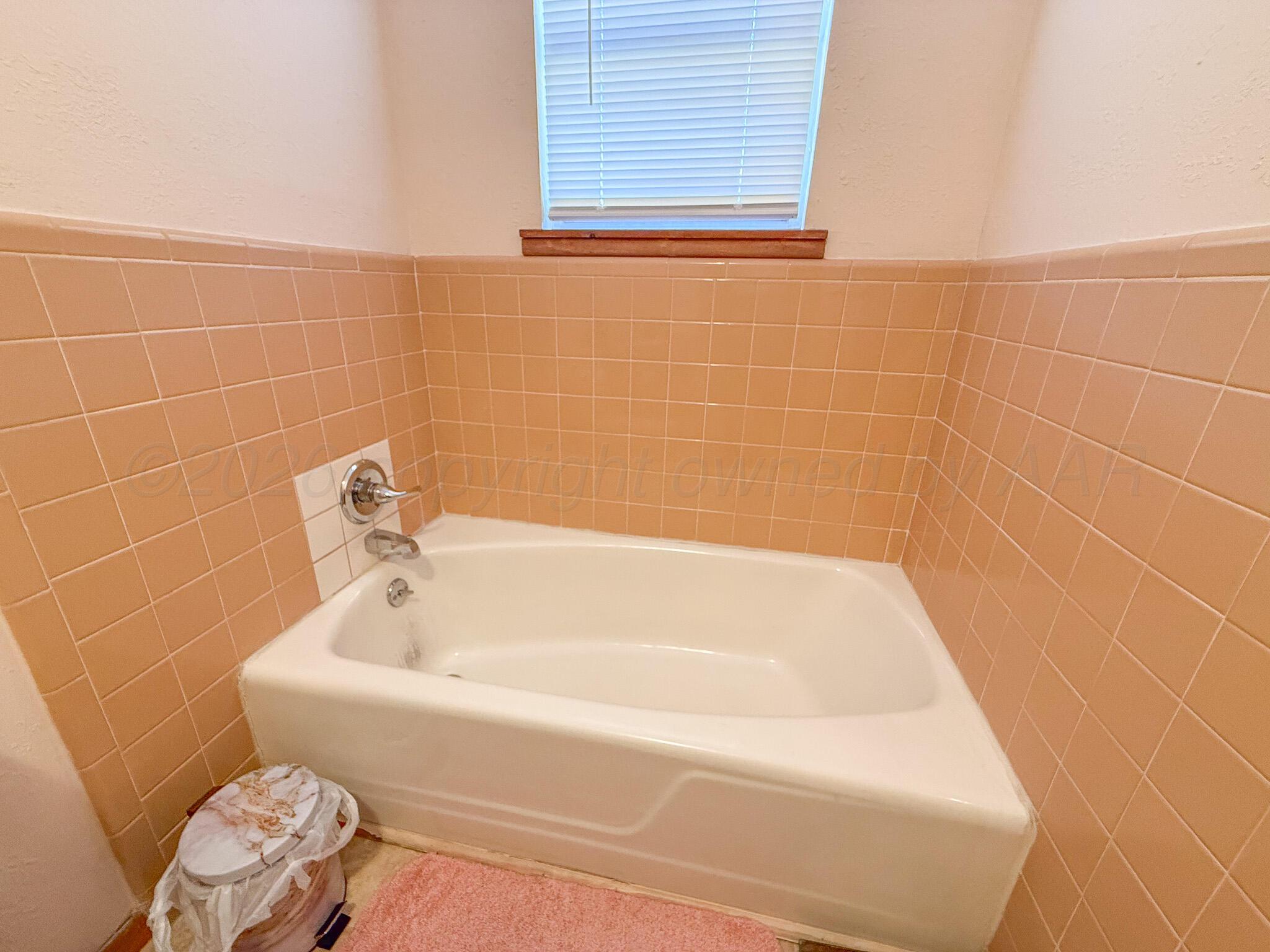 702 South Canadian Street Wheeler, TX 79096 - Photo 27 of 47 a white bath tub sitting next to a white wooden cabinet