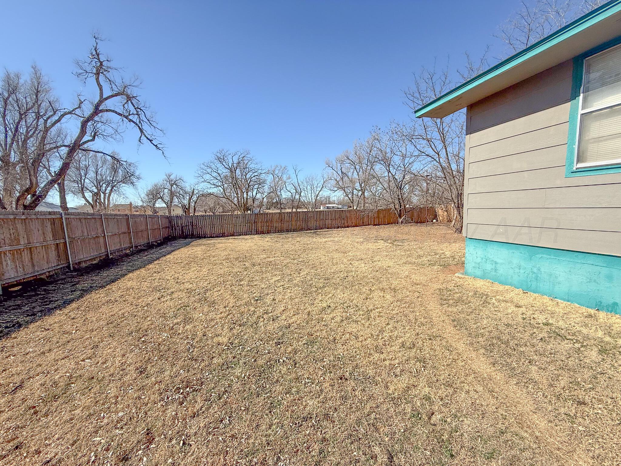 702 South Canadian Street Wheeler, TX 79096 - Photo 35 of 47 a backyard of a house with wooden fence