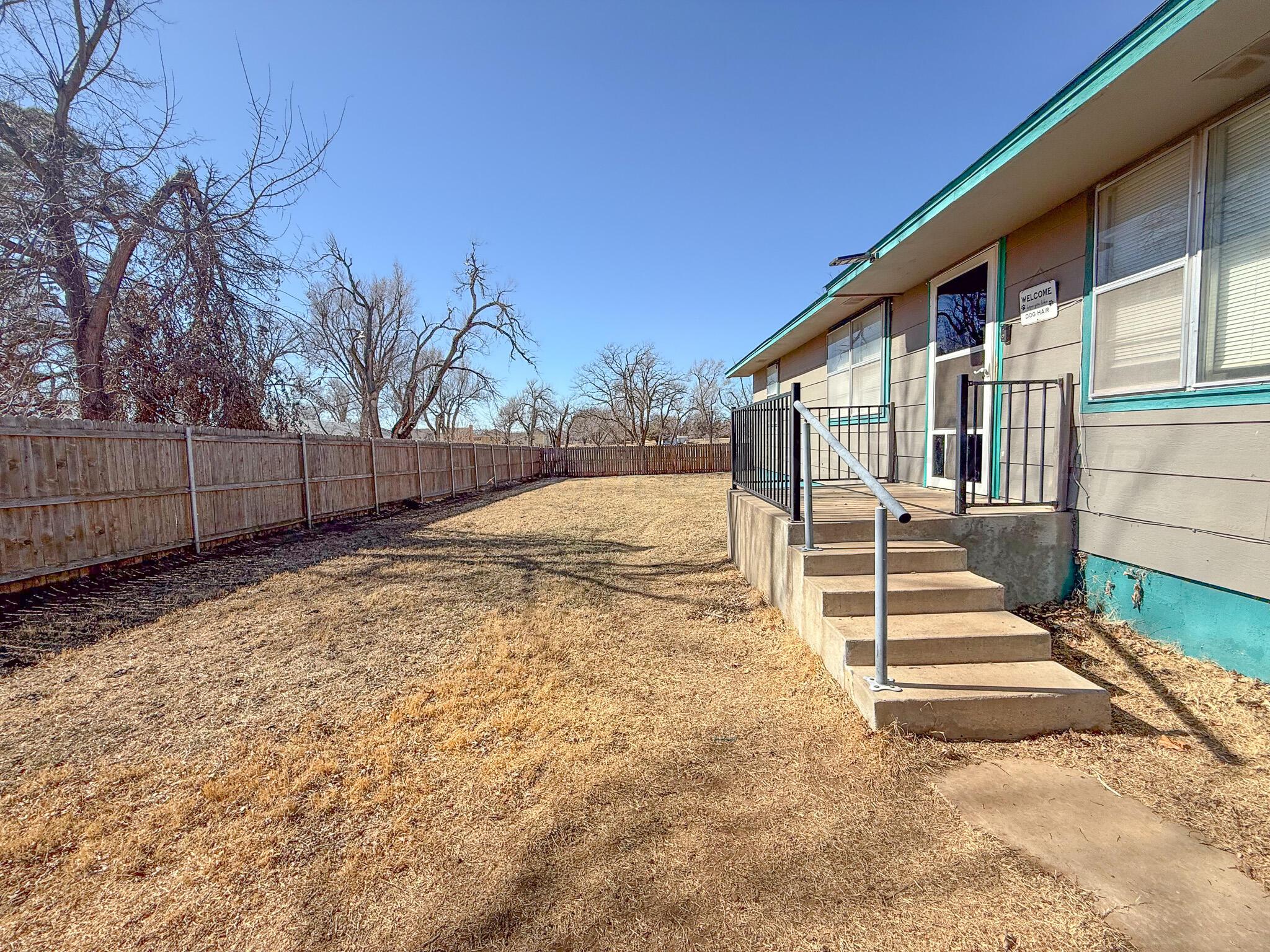 702 South Canadian Street Wheeler, TX 79096 - Photo 4 of 47 a view of backyard with wooden fence and large trees