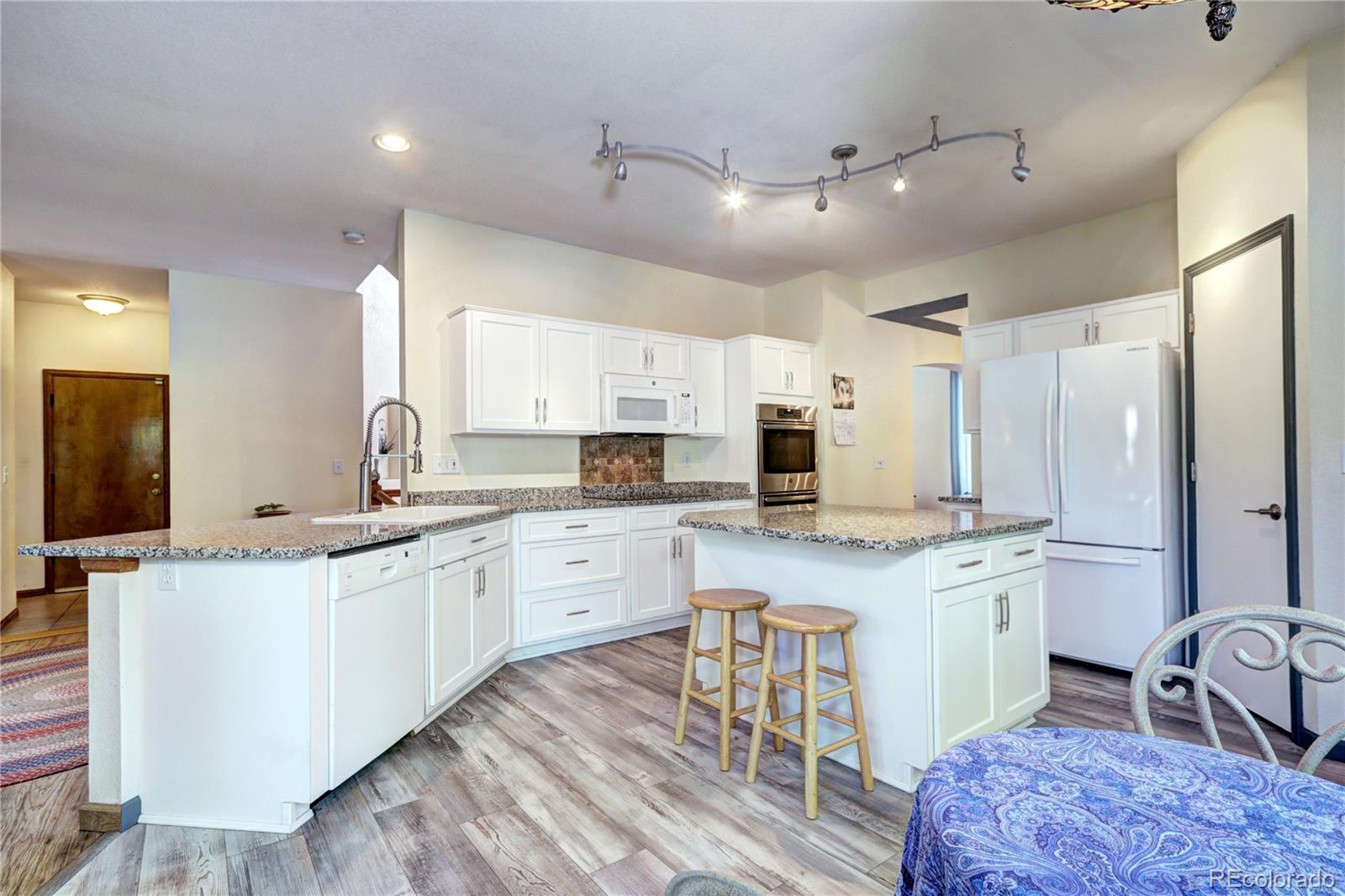 1313 Iris Circle Broomfield, CO 80020 - Photo 10 of 41 a kitchen with stainless steel appliances granite countertop a sink stove and refrigerator