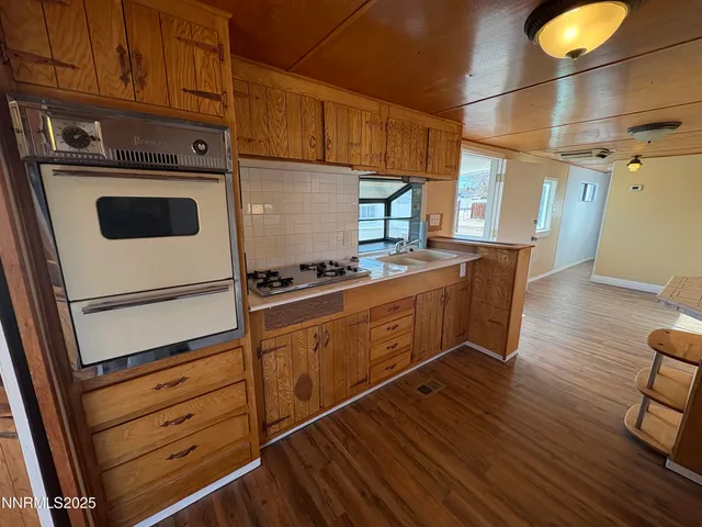 a kitchen with granite countertop wooden cabinets and white appliances