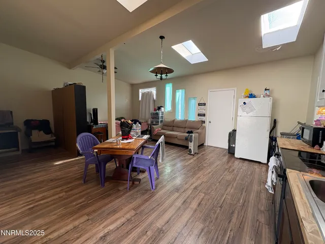 a living room with furniture a dining table and wooden floor