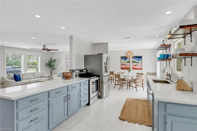 a large white kitchen with a large window and stainless steel appliances