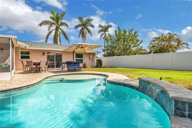 a view of a swimming pool with outdoor seating and a yard
