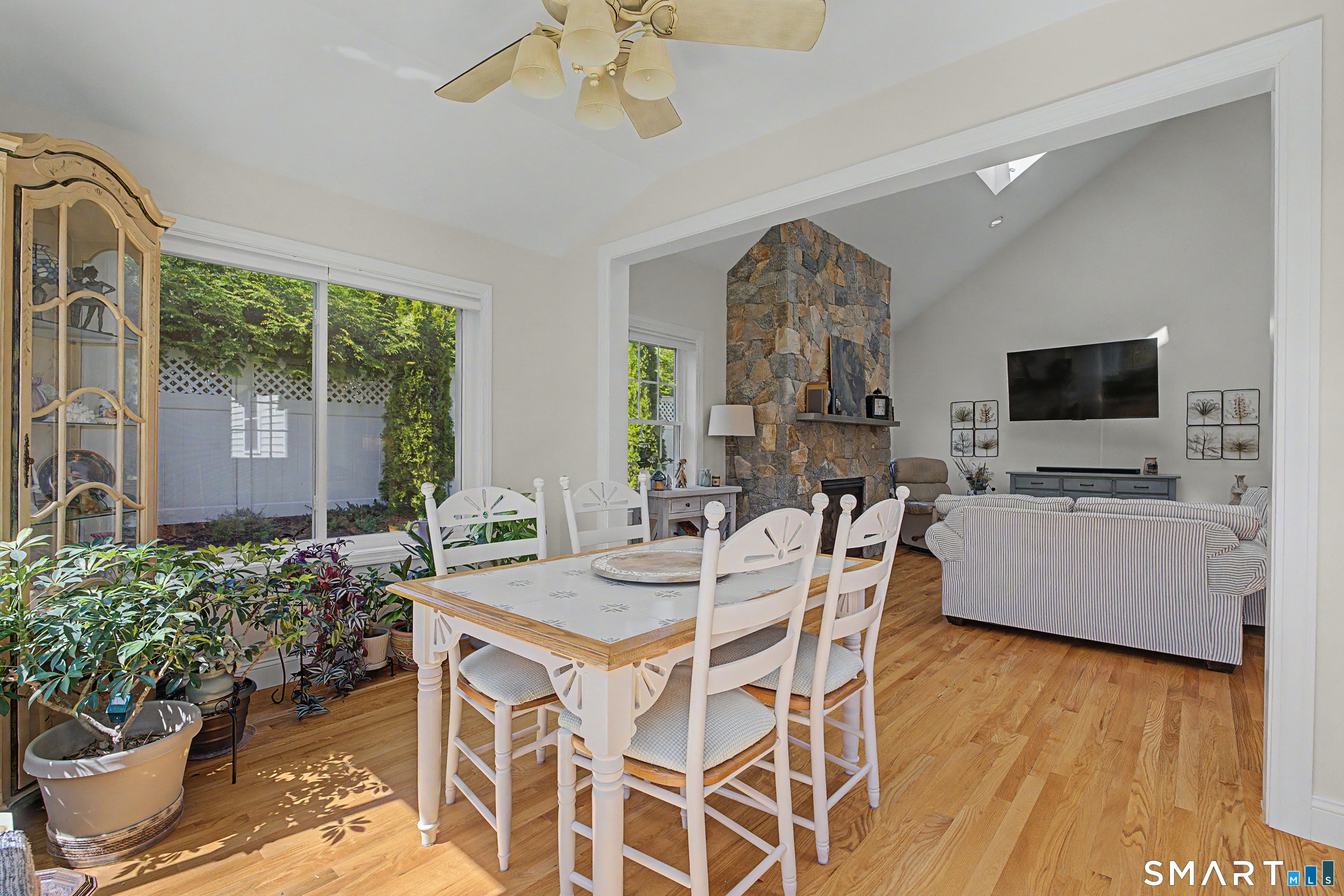 211 Meadowbrook Road, Unit 211 Oxford, CT 06478 - Photo 16 of 38 An open, light-filled layout connects the dining area to a cozy living space with a striking stone fireplace-perfect for effortless everyday living and entertaining.