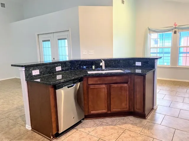 a utility room with stainless steel appliances granite countertop a sink and a stove