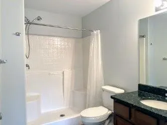 a bathroom with a granite countertop sink toilet and shower