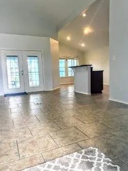 a view of a big room with wooden floor and windows