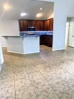 a kitchen with stainless steel appliances granite countertop a sink a stove a microwave a counter top space and cabinets