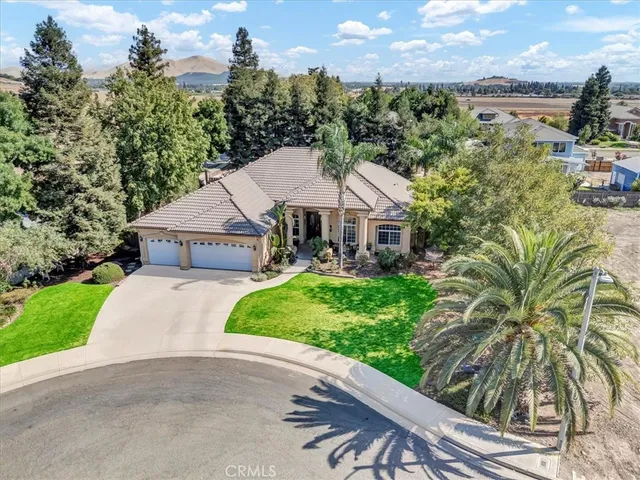 a front view of a house with a yard and potted plants