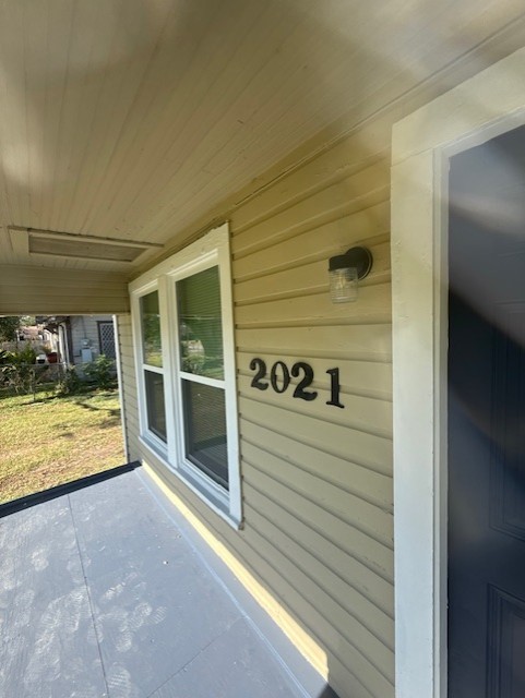 a view of a porch with a door and a rug