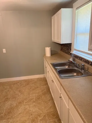 a kitchen with granite countertop a sink and a stove