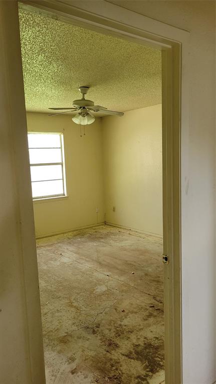 902 South Old Temple Road Hewitt, TX 76643 - Photo 15 of 32 Interior room featuring a ceiling fan with light fixture, textured ceiling, and a window providing natural light