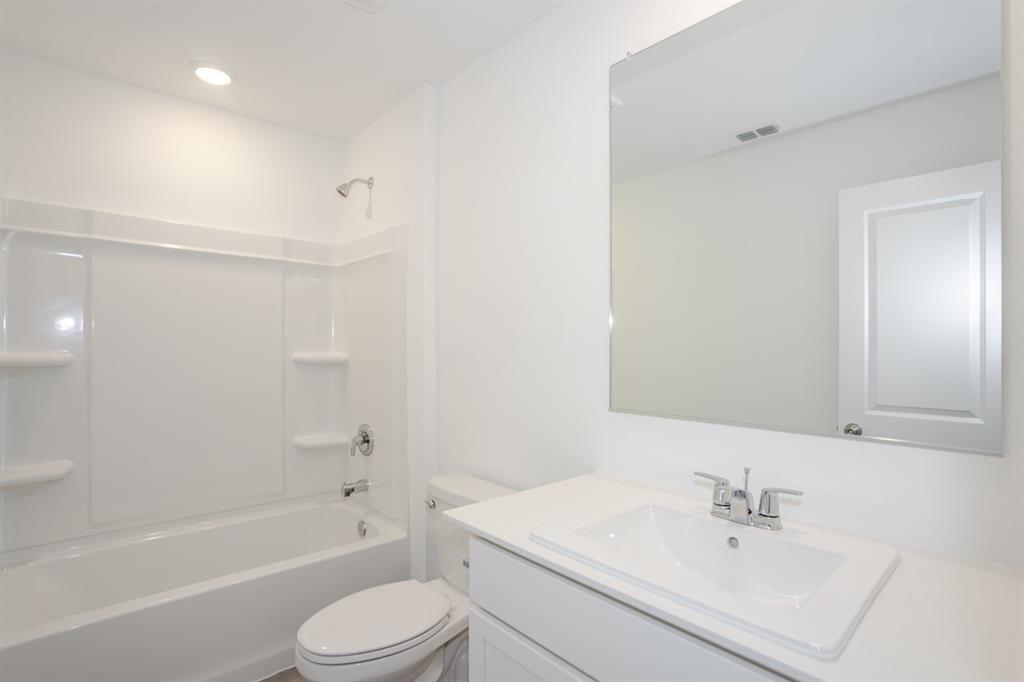 1419 Merlin Blf Street Forney, TX 75126 - Photo 18 of 24 Bathroom featuring a white vanity with an integrated sink, polished chrome faucet, and a large wall-mounted mirror