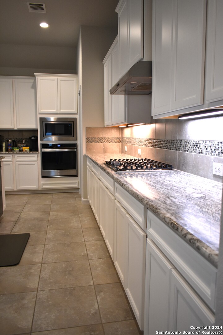 624 Colt Trail Schertz, TX 78154 - Photo 9 of 20 a kitchen with granite countertop a stove and a sink