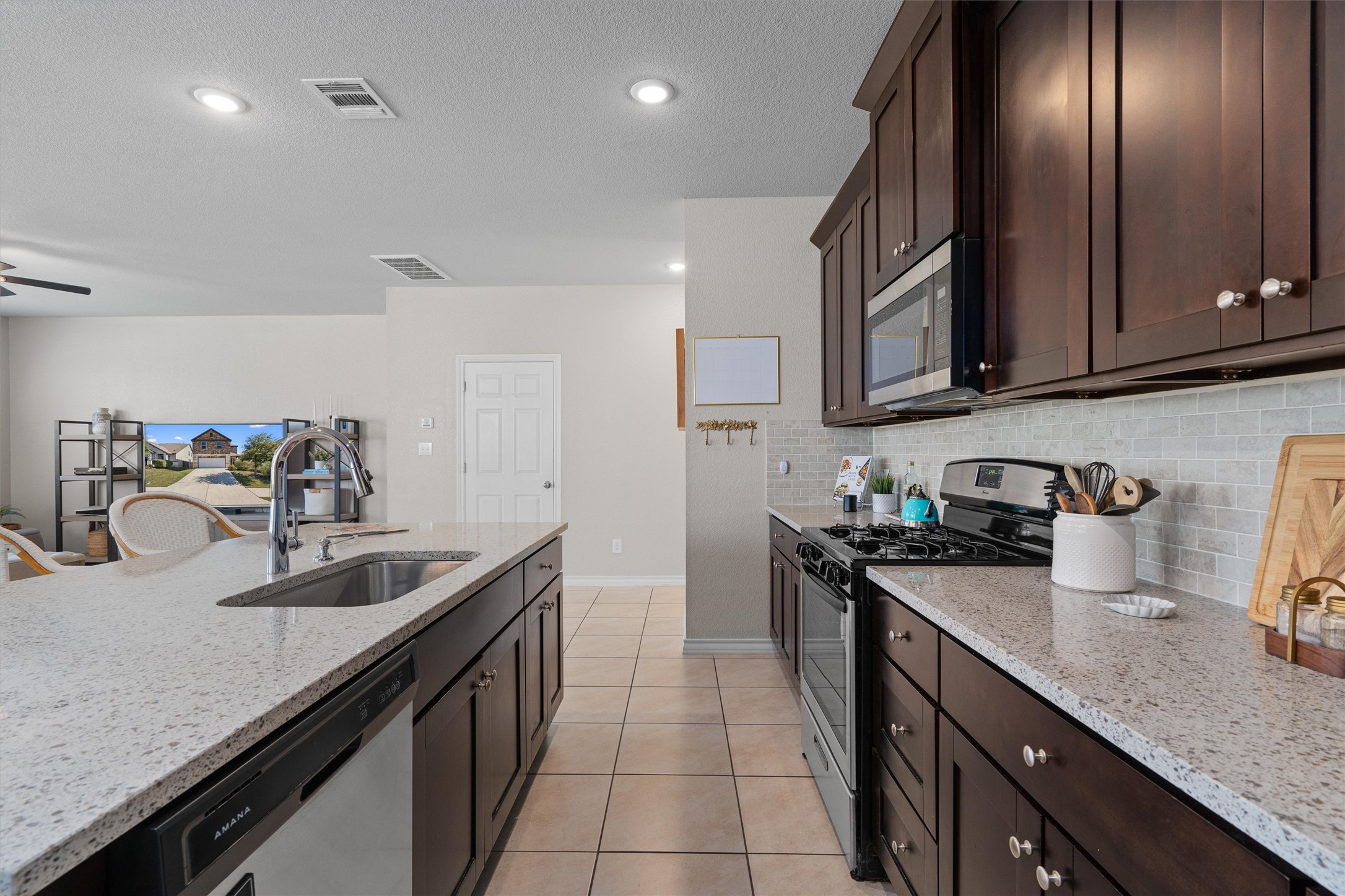 Undisclosed Address Buda, TX 78610 - Photo 13 of 39 a kitchen with granite countertop stainless steel appliances a sink a stove and cabinets