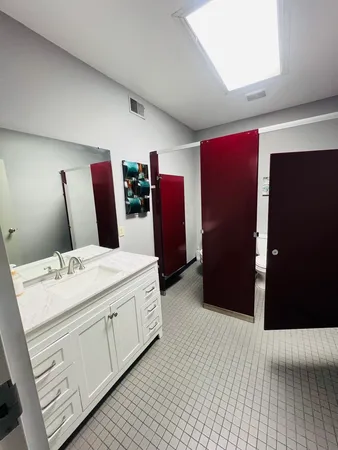 a view of a hallway with wooden floor and a bathroom
