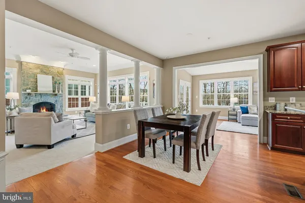 a living room with furniture kitchen view and a wooden floor