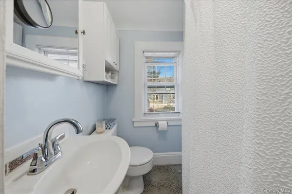 a bathroom with a toilet sink and mirror