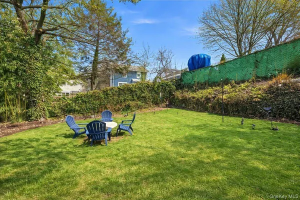 a view of a backyard with table and chairs and plants