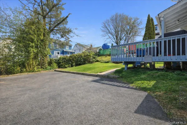 a view of a house with a yard and a bench