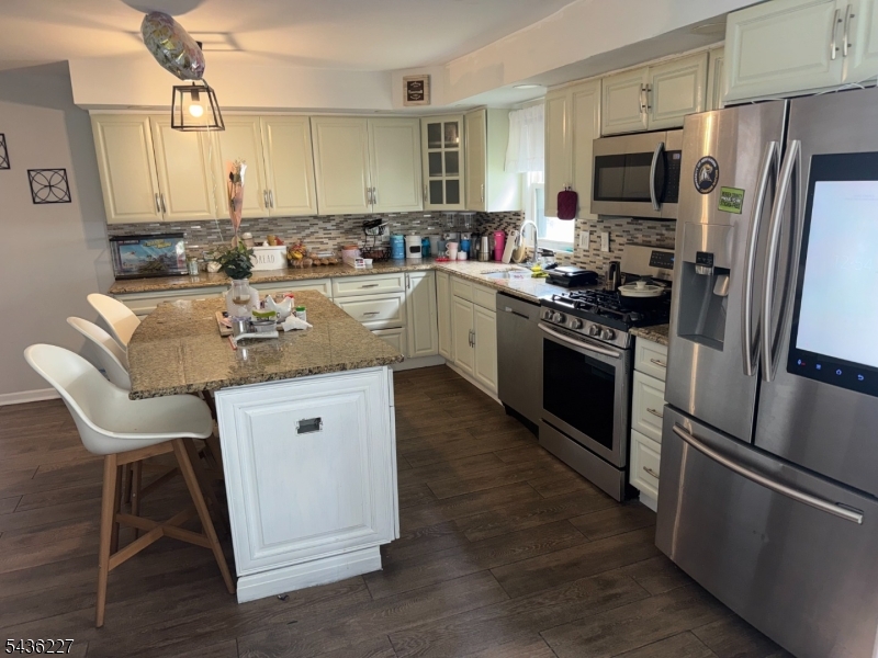 218 Bell Avenue Lodi, NJ 07644 - Photo 5 of 14 a kitchen with stainless steel appliances granite countertop a sink stove refrigerator and microwave