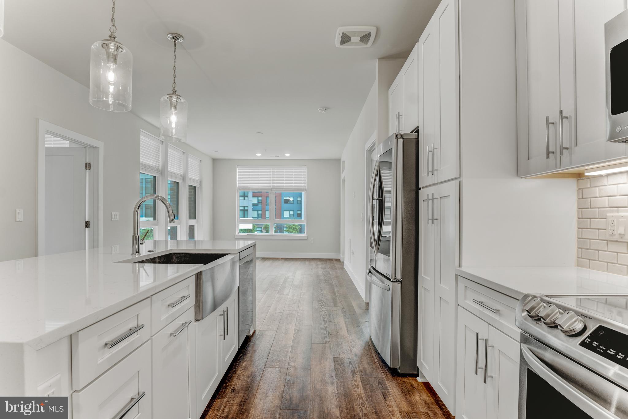 1761 Old Meadow Road, Unit 209 McLean, VA 22102 - Photo 2 of 49 a kitchen with stainless steel appliances granite countertop a refrigerator and a stove top oven