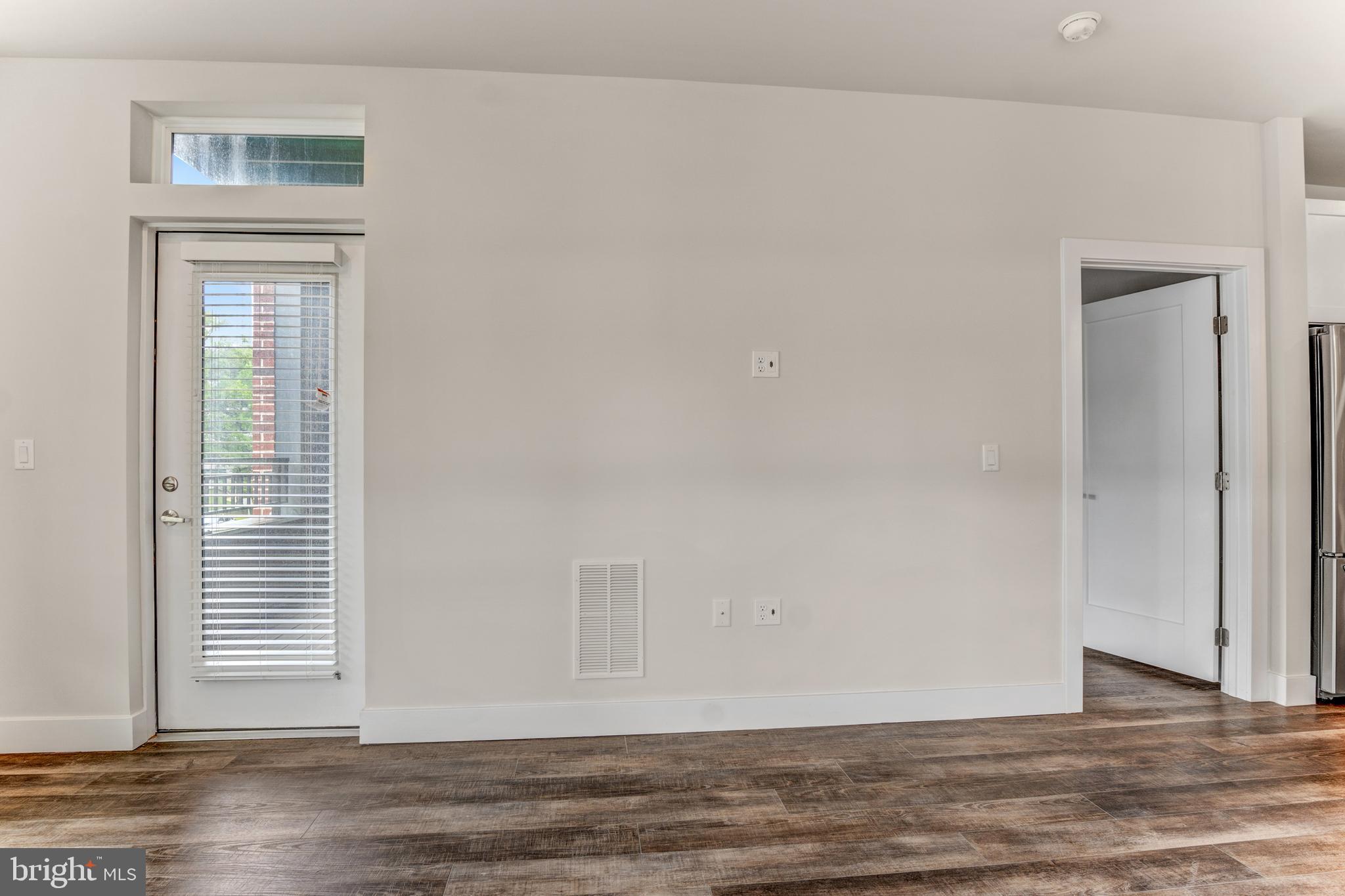 1761 Old Meadow Road, Unit 209 McLean, VA 22102 - Photo 22 of 49 a view of an empty room with wooden floor and a window