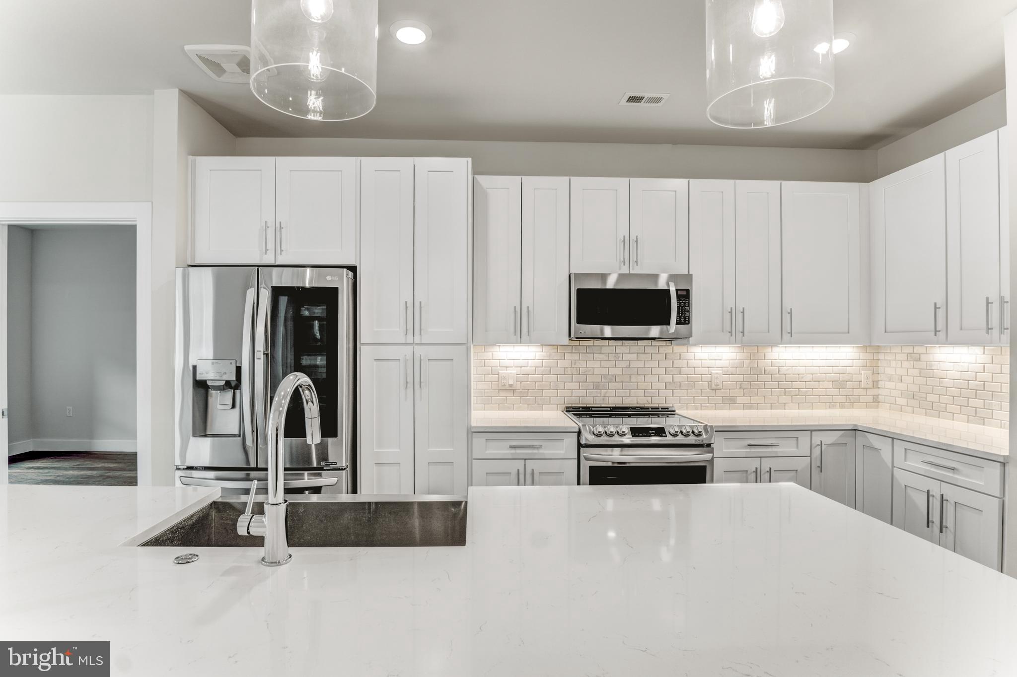 1761 Old Meadow Road, Unit 209 McLean, VA 22102 - Photo 4 of 49 a kitchen with granite countertop a refrigerator and a stove top oven