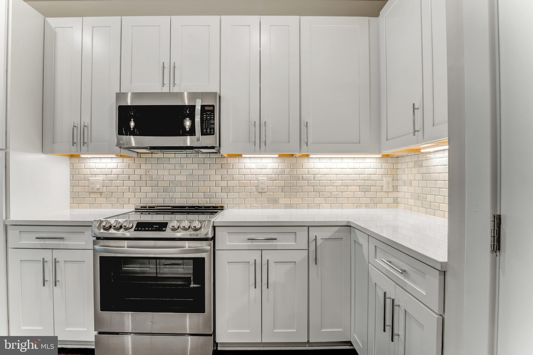 1761 Old Meadow Road, Unit 209 McLean, VA 22102 - Photo 5 of 49 a kitchen with white cabinets and stainless steel appliances