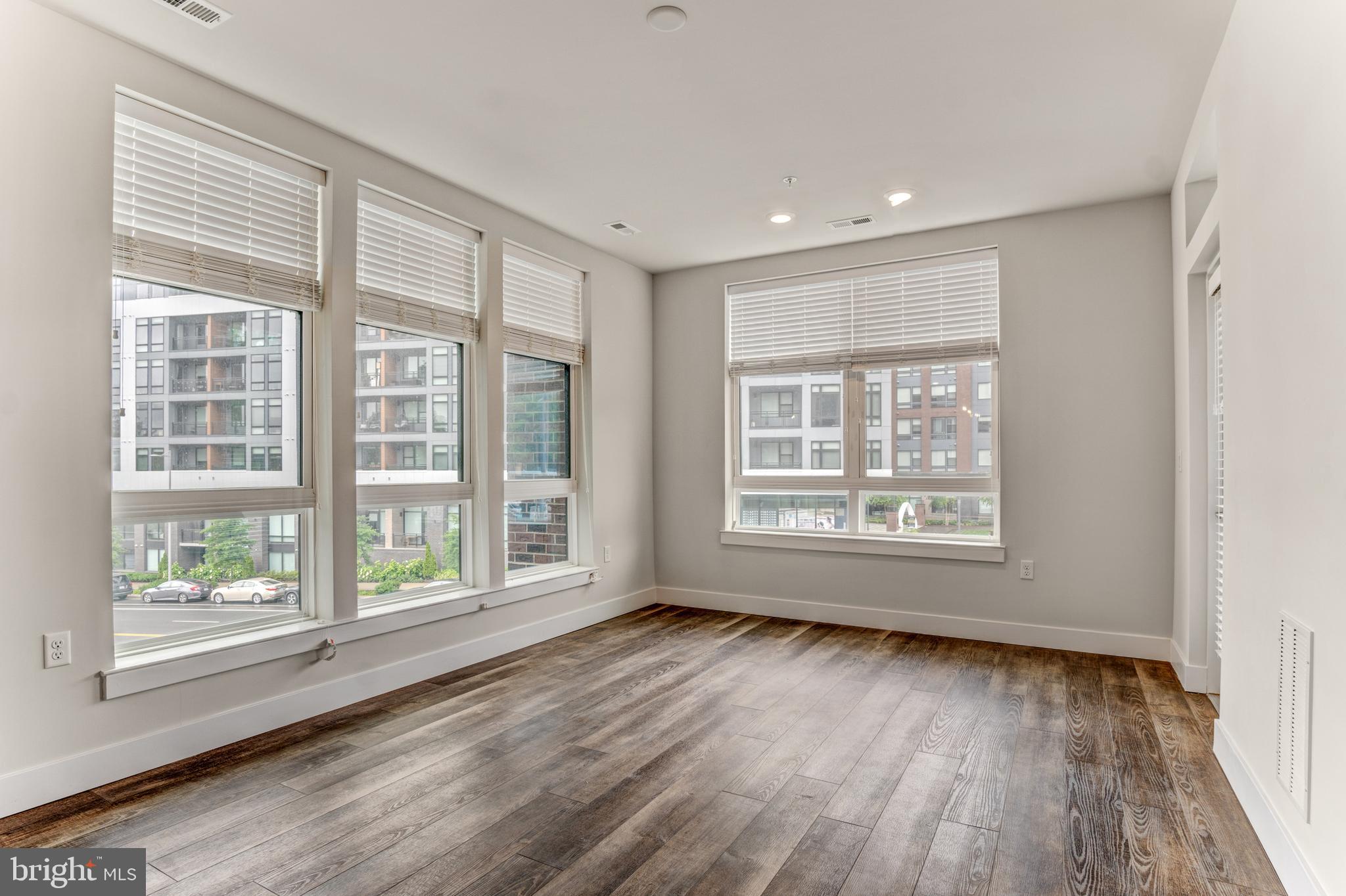 1761 Old Meadow Road, Unit 209 McLean, VA 22102 - Photo 9 of 49 a view of an empty room with wooden floor and a window