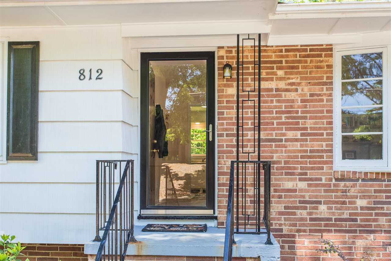 Mostly brick, with original iron work on porch and bay window in living room