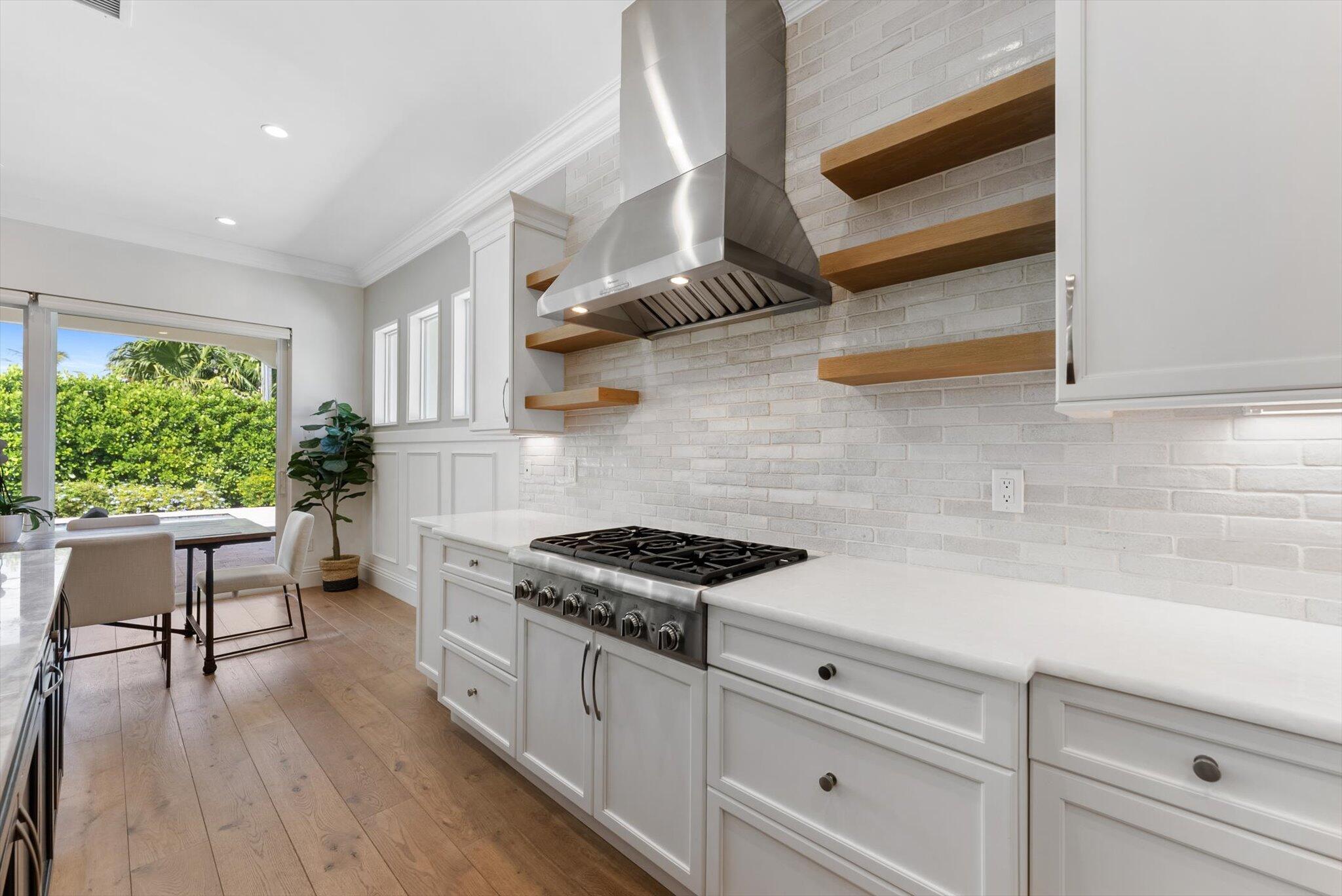 1301 Southwest 15th Street Boca Raton, FL 33486 - Photo 10 of 54 a kitchen with stainless steel appliances white cabinets and wooden floor